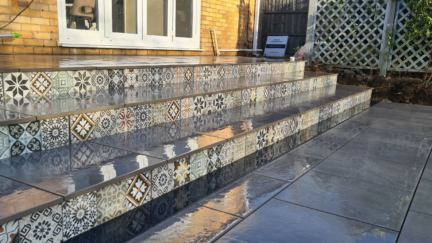 Porcelain steps with patterned tile risers leading up to a patio
