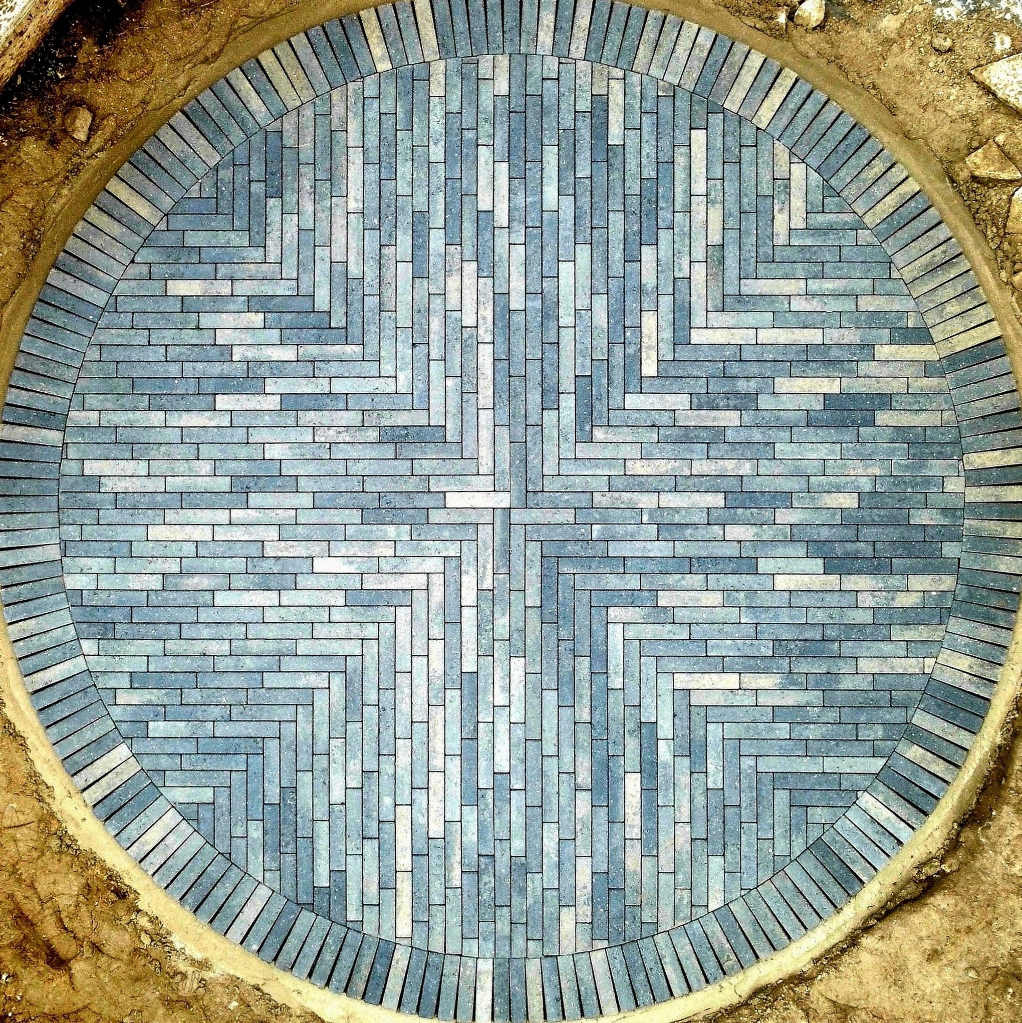 Drone view of a circular herringbone block paving feature being laid