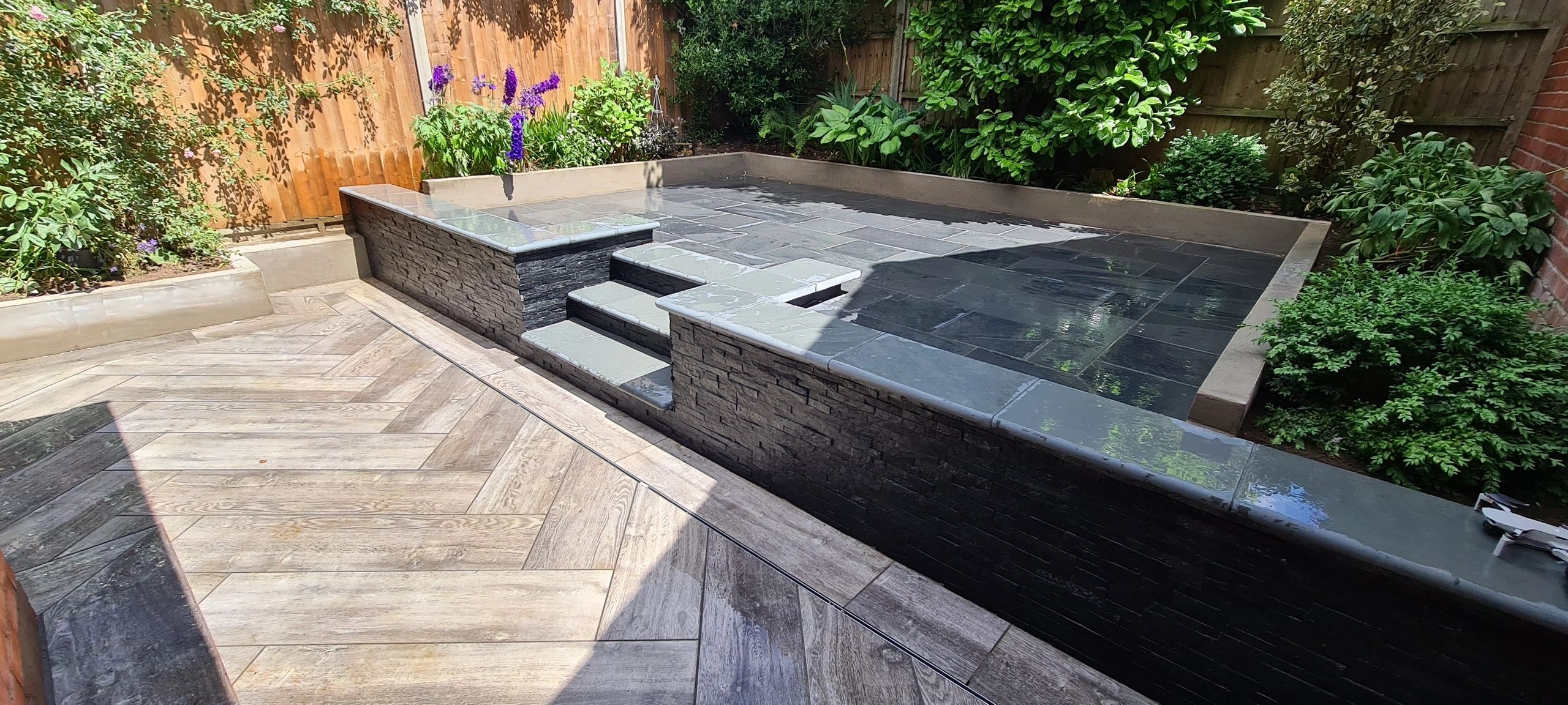 Dark porcelain raised terrace and steps with wood effect paving